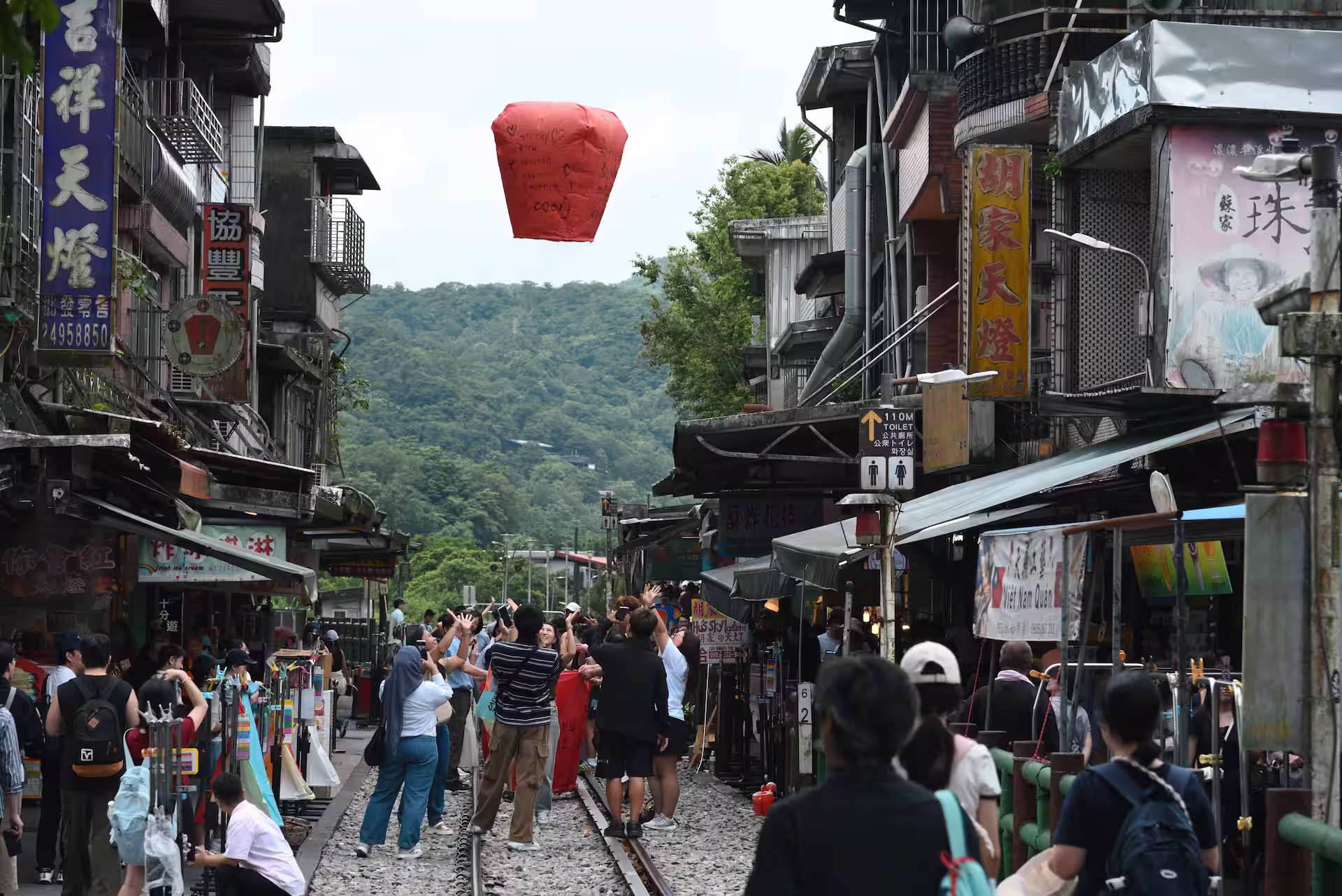 十分老街の線路の上でランタンを上げる人々